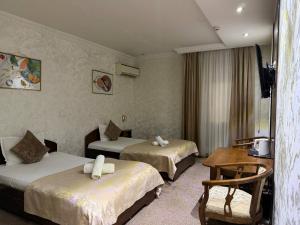 a hotel room with two beds and a table at Nur m hotel Free transfe hotel in airoport in Yakkasaray