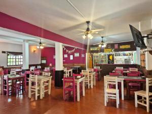 a restaurant with tables and chairs and purple walls at Hotel Spileon in Villa Gesell