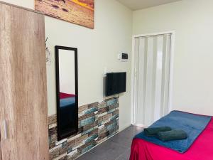 a bedroom with a tv on a brick wall at Bon Bini Kokolishi in Willemstad