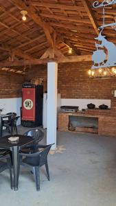 a room with tables and chairs and a stove at Pousada e Camping Caldeirão Furado in São Thomé das Letras