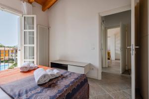 a bedroom with a bed with towels on it at Corte Fasanella 50 in Toscolano Maderno