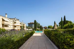 a walkway next to a building and a swimming pool at Corte Fasanella 50 in Toscolano Maderno