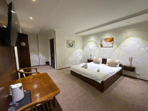 a bedroom with a bed and a table in it at Nur m hotel Free transfe hotel in airoport in Yakkasaray