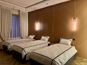 a hotel room with two beds and a window at Hotel VANGOGH in Kyzylorda