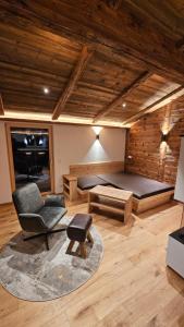 a room with a bed and a chair and a couch at Chalet Schernthann in Salvenberg