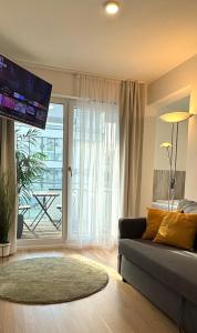 a living room with a couch and a large window at DUTTI'S HOME - 1 Zimmer Apartment, Küche, Self-Check-in, Stellplatz in Ingolstadt +5 photos