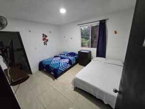 a bedroom with two beds and a window at Finca hotel los cocos in Montenegro +126 photos