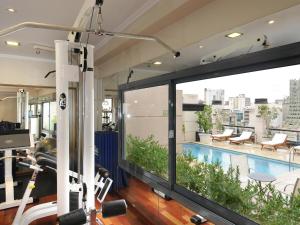 a gym with a large window and a swimming pool at Windsor Hotel in Córdoba