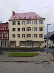 a large yellow building with a red roof at Apartmány u Klínovce in Vejprty