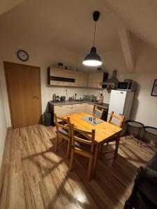 a kitchen and dining room with a wooden table and chairs at Apartmány u Klínovce in Vejprty