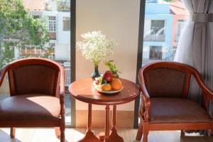 two chairs and a table with a bowl of fruit at Som Phu Quy 3 Hotel Phan Rang in Phan Rang–Tháp Chàm