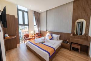 a hotel room with a bed and a mirror at Som Phu Quy 3 Hotel Phan Rang in Phan Rang–Tháp Chàm