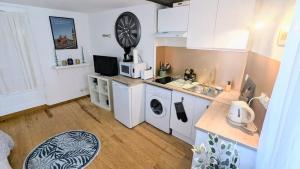 a kitchen with a sink and a washing machine at Cosy Planta - 2 lits - Hyper Centre & Clémenceau - 1 parking sous terrain in Pau