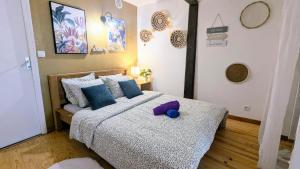 a bedroom with a bed with a purple stuffed animal on it at Cosy Planta - 2 lits - Hyper Centre & Clémenceau - 1 parking sous terrain in Pau