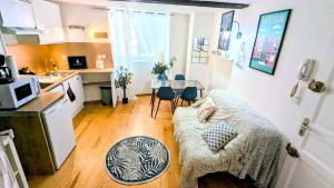 a small living room with a couch and a kitchen at Cosy Planta - 2 lits - Hyper Centre & Clémenceau - 1 parking sous terrain in Pau