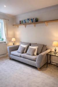 a couch sitting in a living room with two lamps at Fernhill Hideaway in Charmouth