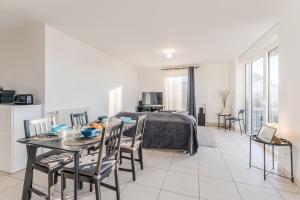 a living room with a bed and a table and chairs at Dumbo - Île de Nantes in Nantes