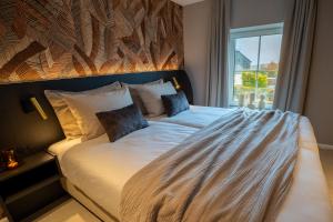 a bedroom with a large bed with a window at Manoir Kasselslay in Roder +5 photos