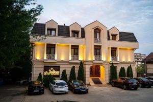 a building with cars parked in front of it at Pensiunea Crystal in Iaşi