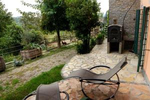 a chair sitting on a patio next to a grill at Bay Cottage in Verrua Savoia