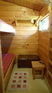 eine Blockhütte mit einem Bett und einem Tisch in der Unterkunft scuderia club house in Susa