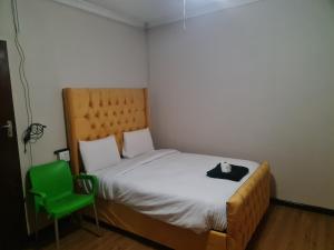 a small bedroom with a bed and a green chair at Hasate Guest House ,4 st james street Oakdale Belliville Cape Town South Africa in Cape Town +126 photos