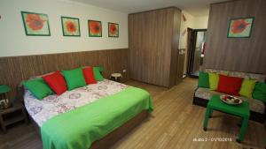 a bedroom with a green bed and a couch at City Studio Rent Varna in Varna City