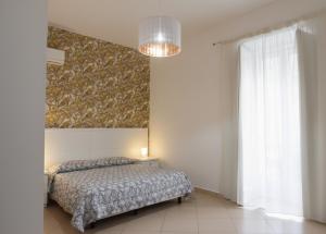 a bedroom with a bed and a large window at La Locanda del Baffo in Capua