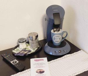 a table with a coffee maker and a remote control at Zimmer mit Terrasse am Jakobsberg in Ockenheim