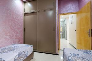 a bedroom with pink walls and a sliding door at Riad Bollywood-Golden Stay D in Benguerir +1 photo