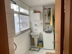 a small bathroom with a toilet and a sink at Apartamento junto mar, bem ventilado e iluminado - Antilhas 679 in Capão da Canoa +12 photos