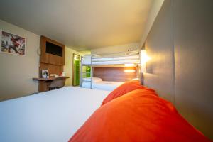 a bedroom with a bed with an orange blanket at Brit hôtel confort Ampaline Périgueux est in Boulazac +36 photos