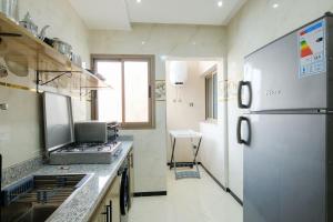 a kitchen with a stainless steel refrigerator and a sink at Riad Bollywood-Golden Stay D in Benguerir