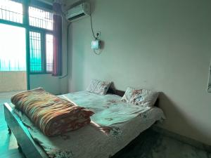 a bedroom with a bed in a room with a window at Krishna guest house in Sāmbhar