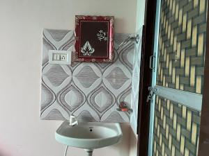 a bathroom with a sink and a sign on the wall at Krishna guest house in Sāmbhar +4 photos