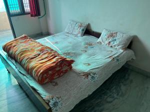 a bed with a comforter and pillows on it at Krishna guest house in Sāmbhar