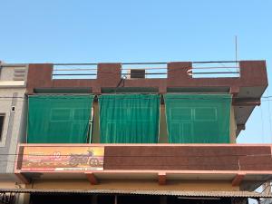 a building with green curtains on top of a bench at Krishna guest house in Sāmbhar