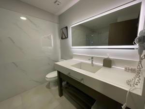 a white bathroom with a sink and a mirror at Esplendor by Wyndham Los Mochis Country Place in Los Mochis +52 photos