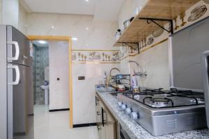 a kitchen with a sink and a stove at Riad Bollywood-Golden Stay D in Benguerir