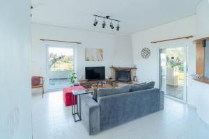 a living room with a couch and a tv at Villa Antheon in Kalamákion