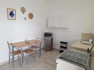a small kitchen with a table and chairs and a stove at Sol de Ayangue in Ayangue