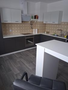 a kitchen with a white counter and a black chair at Ferienwohnung Lina in Nistertal