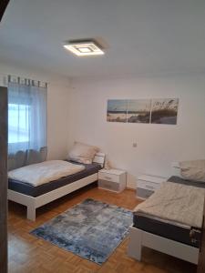 a bedroom with two beds and a rug at Ferienwohnung Lina in Nistertal