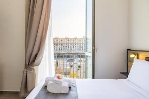 a hotel room with a bed and a large window at Sant'Angelo Station in Naples