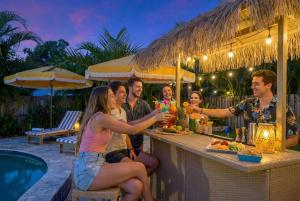 a group of people sitting at a bar with drinks at Resort Style Backyard Pool Hot Tub Games in Seminole