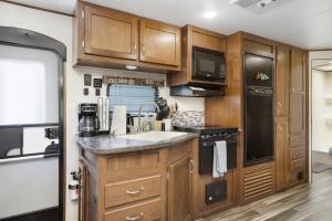 a kitchen with wooden cabinets and a sink at Perfect camper for your vacation in Ellenton