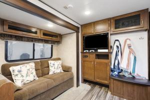 a living room in a rv with a couch and a tv at Perfect camper for your vacation in Ellenton