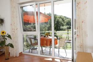 a room with a table and a balcony with an umbrella at Ferienwohnungen Holder in Anhausen