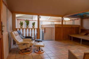 a room with chairs and a table on a balcony at Moving Rooms in Wimpassing