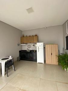 a kitchen with a white refrigerator and a table at Refugio Aconchegante2 in Nova Mutum